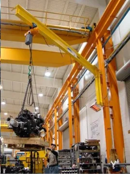 Yellow jib crane lifting a load inside a workshop